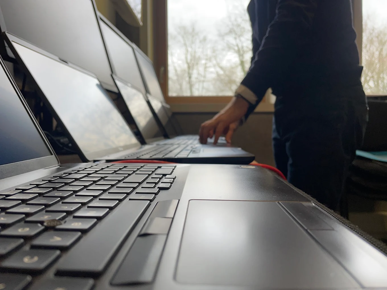 Atelier OPP de réparation à Nantes : techniciens au travail sur des laptops et smartphones